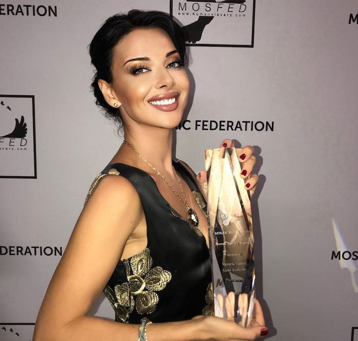 Victoria Unikel holding the top art prize at the MOSAIC Federation gala